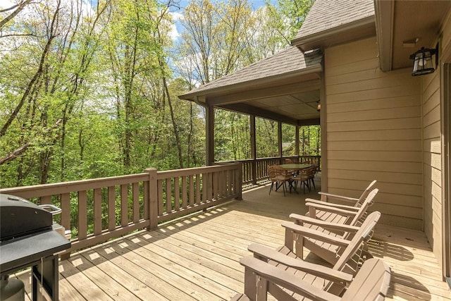 deck featuring outdoor dining area and grilling area