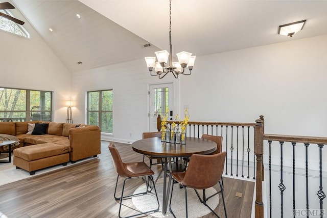 dining room featuring wood-type flooring, an inviting chandelier, and high vaulted ceiling