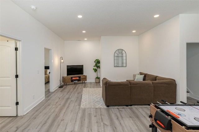 living room with light wood-type flooring, recessed lighting, and baseboards
