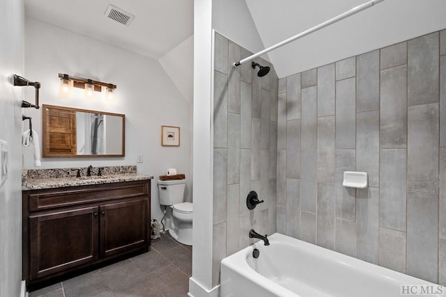 full bathroom featuring lofted ceiling, tile patterned floors, toilet, vanity, and tiled shower / bath combo