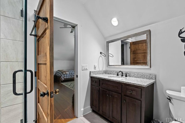 bathroom with a shower with door, lofted ceiling, tile patterned flooring, toilet, and vanity