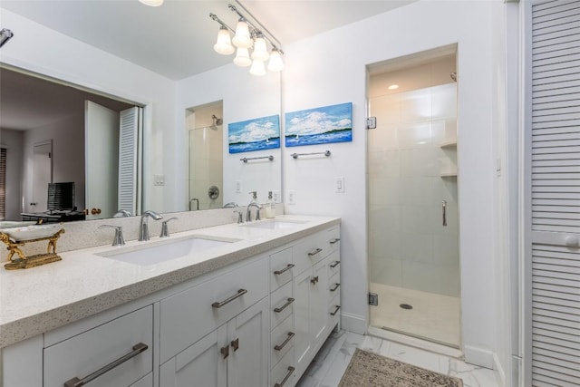 bathroom with marble finish floor, a sink, a shower stall, and double vanity