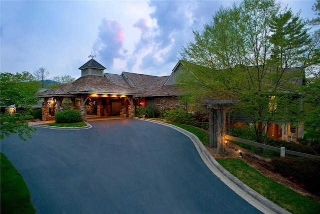 view of front of property with stone siding and aphalt driveway