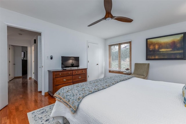 bedroom with wood finished floors, a ceiling fan, and baseboards