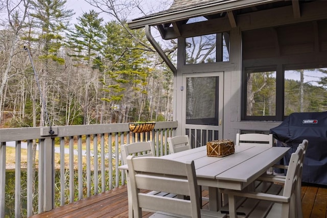 wooden terrace with outdoor dining space and area for grilling