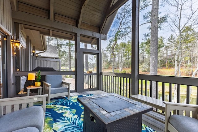 sunroom featuring lofted ceiling with beams