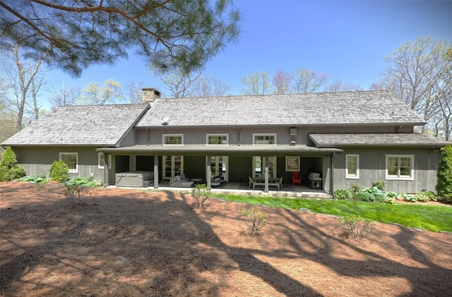 212 Ivorybill Way, Cashiers, NC 28717 - back of house with a hot tub, a patio area, and a chimney