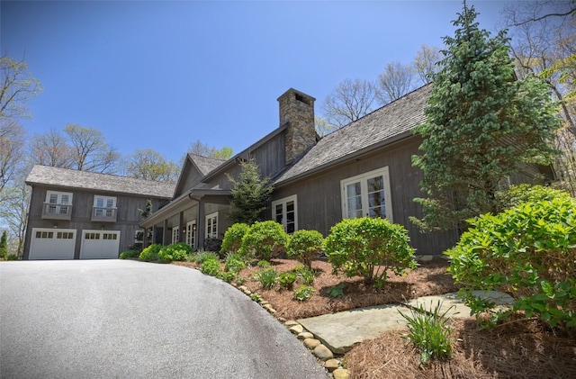 212 Ivorybill Way, Cashiers, NC 28717 - view of front of home featuring an attached garage, aphalt driveway, and a chimney