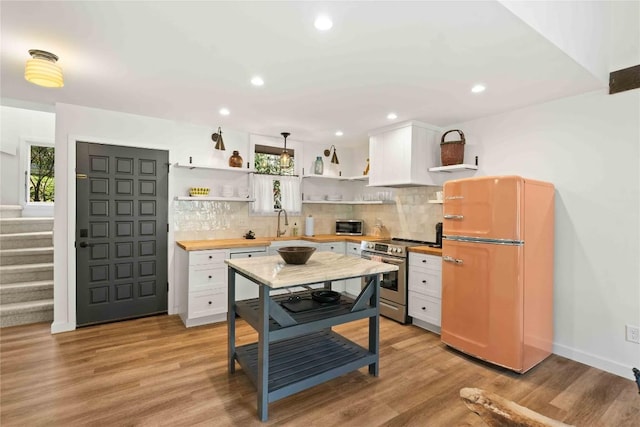 kitchen featuring appliances with stainless steel finishes, open shelves, backsplash, and a wealth of natural light