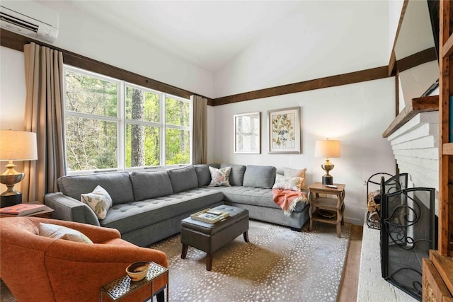 living room featuring an AC wall unit, vaulted ceiling, wood finished floors, and a fireplace