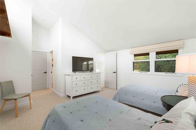 bedroom featuring baseboards, lofted ceiling, and light carpet