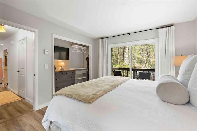 bedroom featuring baseboards, access to outside, and wood finished floors
