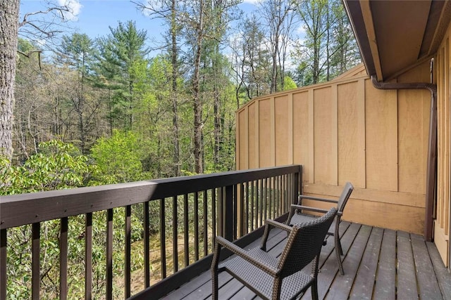wooden deck with a wooded view
