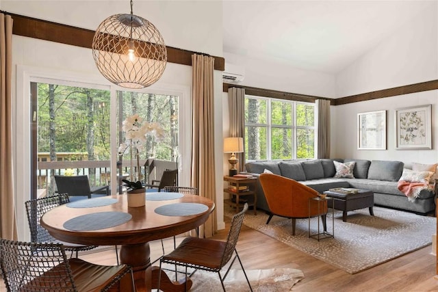 living room with light wood-type flooring, a wealth of natural light, and high vaulted ceiling