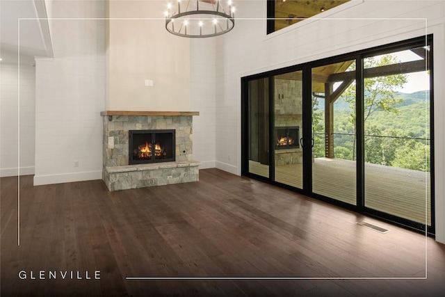 237 Glassy Rock Ln, Glenville, NC 28736 - unfurnished living room with a stone fireplace, dark wood finished floors, a chandelier, and a high ceiling