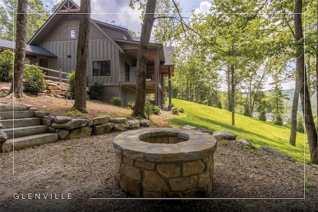 237 Glassy Rock Ln, Glenville, NC 28736 - rear view of house featuring board and batten siding, an outdoor fire pit, and a lawn