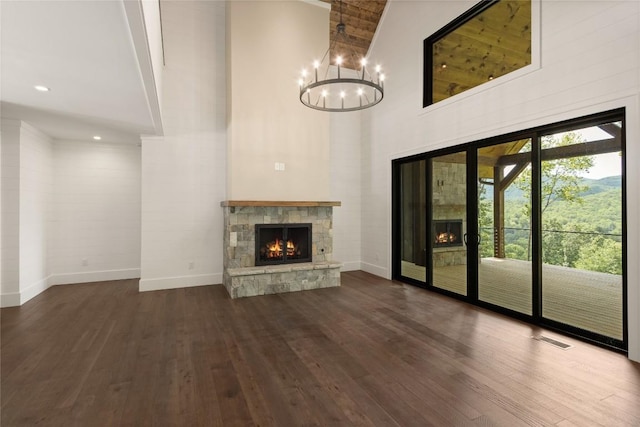 237 Glassy Rock Ln, Glenville, NC 28736 - unfurnished living room with a stone fireplace, high vaulted ceiling, dark wood-type flooring, a chandelier, and beamed ceiling