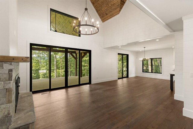 237 Glassy Rock Ln, Glenville, NC 28736 - unfurnished living room featuring a chandelier, a stone fireplace, high vaulted ceiling, and dark wood-style floors