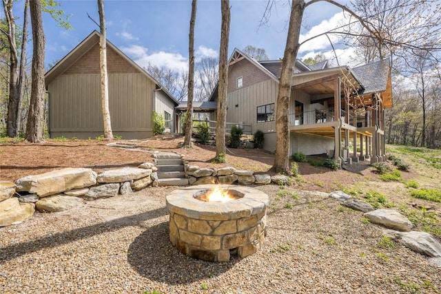 exterior space with a wooden deck, stairs, and an outdoor fire pit