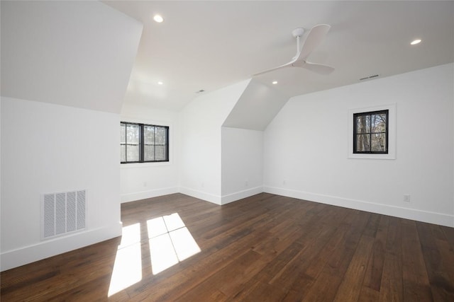 additional living space with baseboards, lofted ceiling, wood finished floors, and visible vents