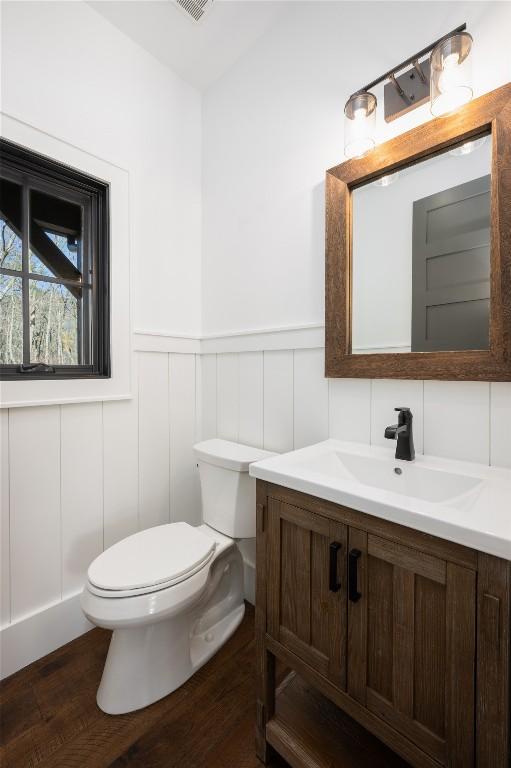 bathroom with hardwood / wood-style flooring, vanity, and toilet