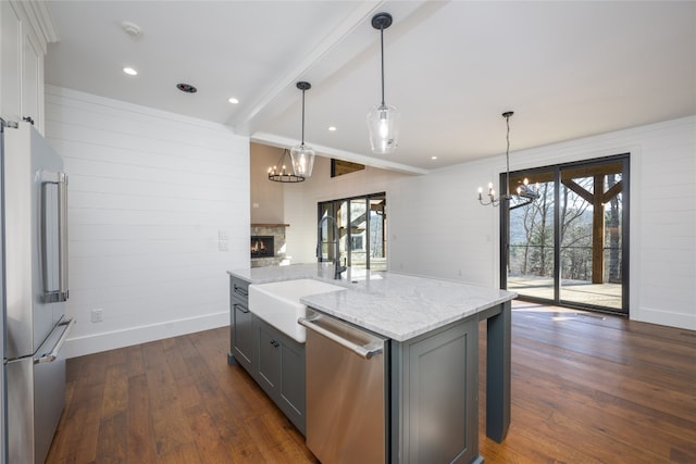 kitchen with sink, gray cabinetry, decorative light fixtures, a center island with sink, and appliances with stainless steel finishes