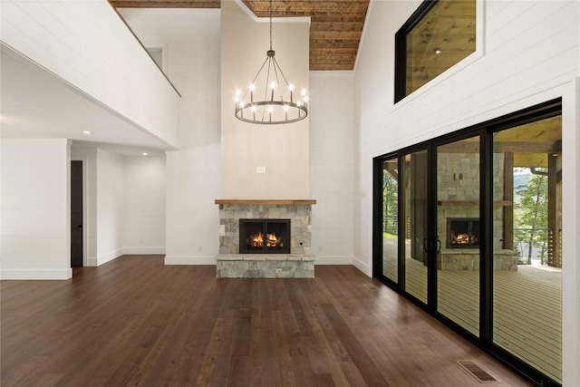 237 Glassy Rock Ln, Glenville, NC 28736 - unfurnished living room featuring a fireplace, a high ceiling, dark wood-type flooring, and a chandelier