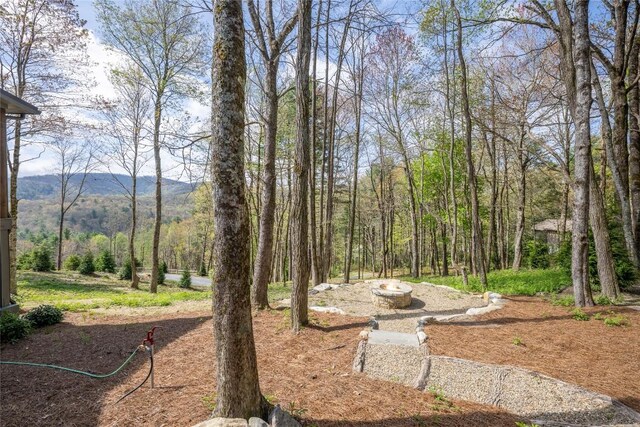 view of yard with a forest view and a mountain view