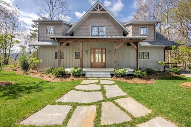 view of front facade featuring covered porch, board and batten siding, and a front yard