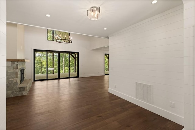 237 Glassy Rock Ln, Glenville, NC 28736 - unfurnished living room featuring a chandelier, recessed lighting, dark wood finished floors, and a stone fireplace