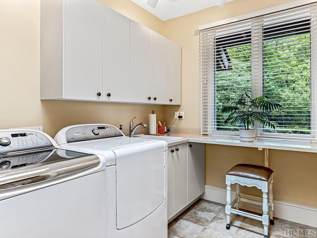 laundry room featuring independent washer and dryer, sink, plenty of natural light, and cabinets