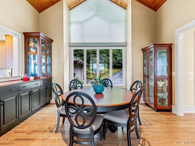 dining space featuring light wood-type flooring, high vaulted ceiling, and wooden ceiling