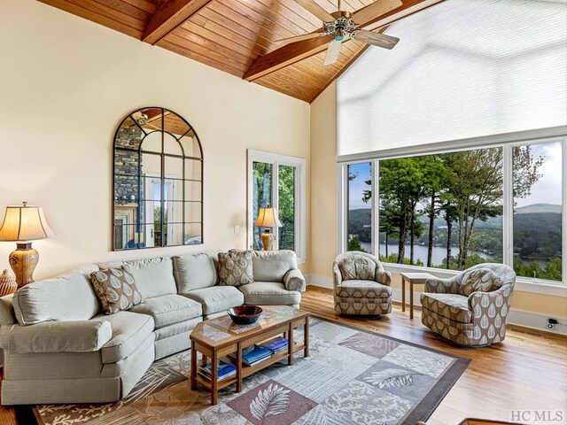 living room featuring vaulted ceiling with beams, wooden ceiling, ceiling fan, and light hardwood / wood-style flooring