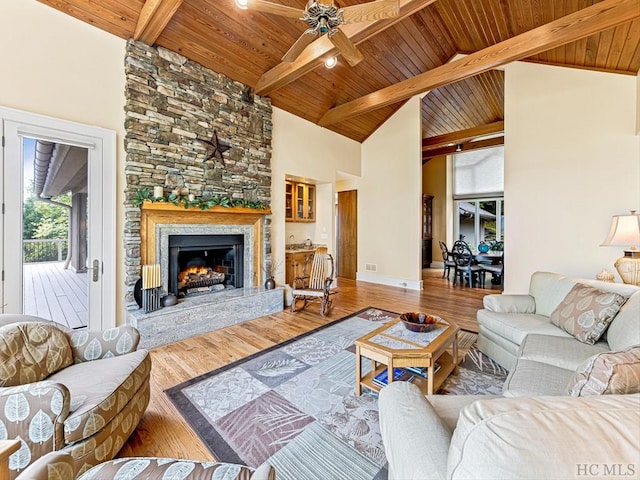 living room featuring wood ceiling, wood-type flooring, high vaulted ceiling, beamed ceiling, and a fireplace