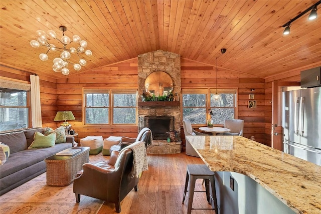 living area with wooden walls, wooden ceiling, hardwood / wood-style flooring, and a healthy amount of sunlight