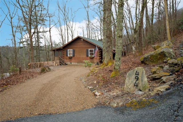 view of side of property featuring crawl space, driveway, and log siding