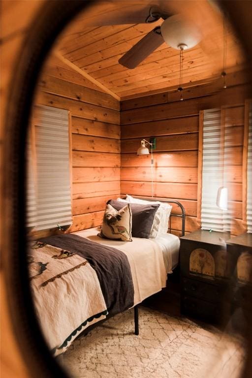 bedroom featuring wooden ceiling, wood walls, and ceiling fan