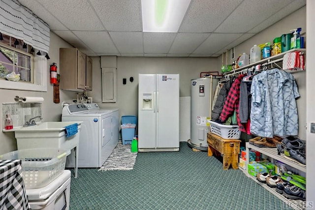 clothes washing area with cabinets, washer and clothes dryer, sink, and water heater