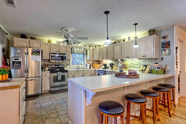 kitchen featuring decorative backsplash, stainless steel appliances, a kitchen breakfast bar, and sink