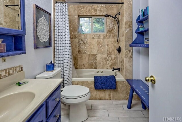 full bathroom featuring shower / tub combo with curtain, vanity, tile patterned flooring, and toilet