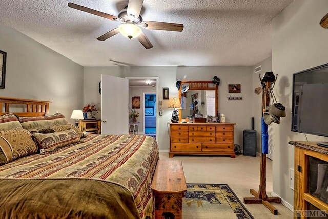 carpeted bedroom with a textured ceiling and ceiling fan