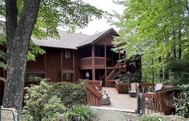 back of property with a deck and a shingled roof