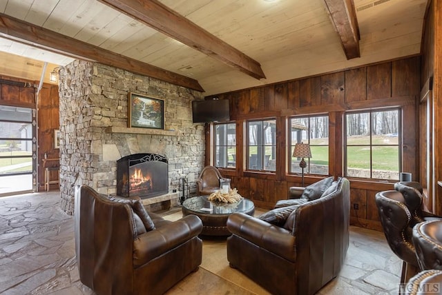 359 Outpost Trl, Glenville, NC 28736 - living area featuring wooden ceiling with exposed beams, stone floors, healthy amount of natural light, a stone fireplace, and wood walls