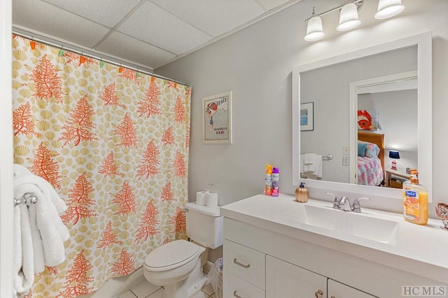 full bathroom featuring a drop ceiling, toilet, a shower with shower curtain, vanity, and tile patterned floors