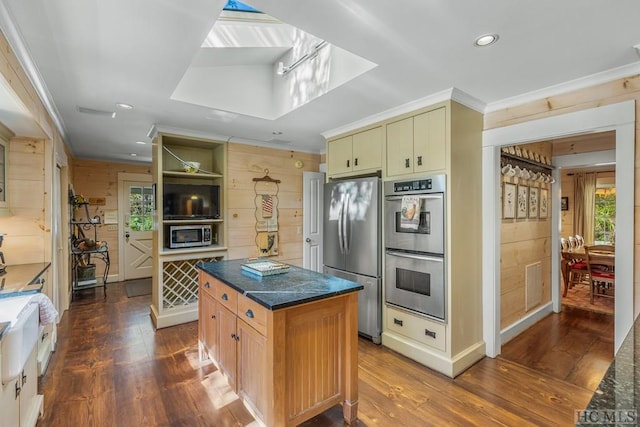 kitchen with dark wood-style floors, visible vents, wooden walls, and appliances with stainless steel finishes