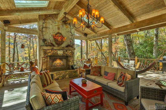 sunroom / solarium featuring wooden ceiling, vaulted ceiling with skylight, and an outdoor stone fireplace