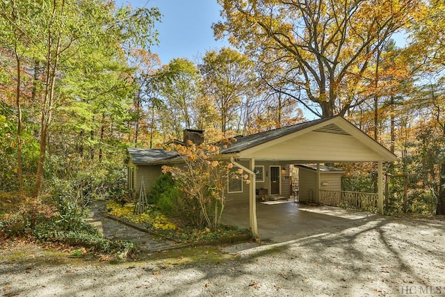 exterior space with a carport and a chimney