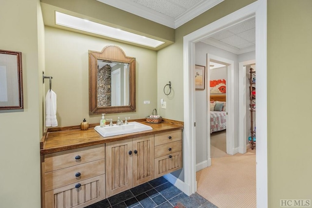 bathroom with ornamental molding, vanity, and baseboards