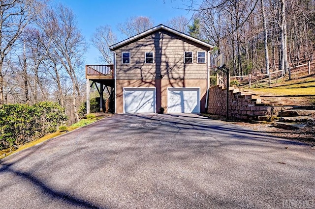 view of side of home featuring a garage and a deck