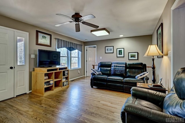 living room featuring ceiling fan and light hardwood / wood-style flooring